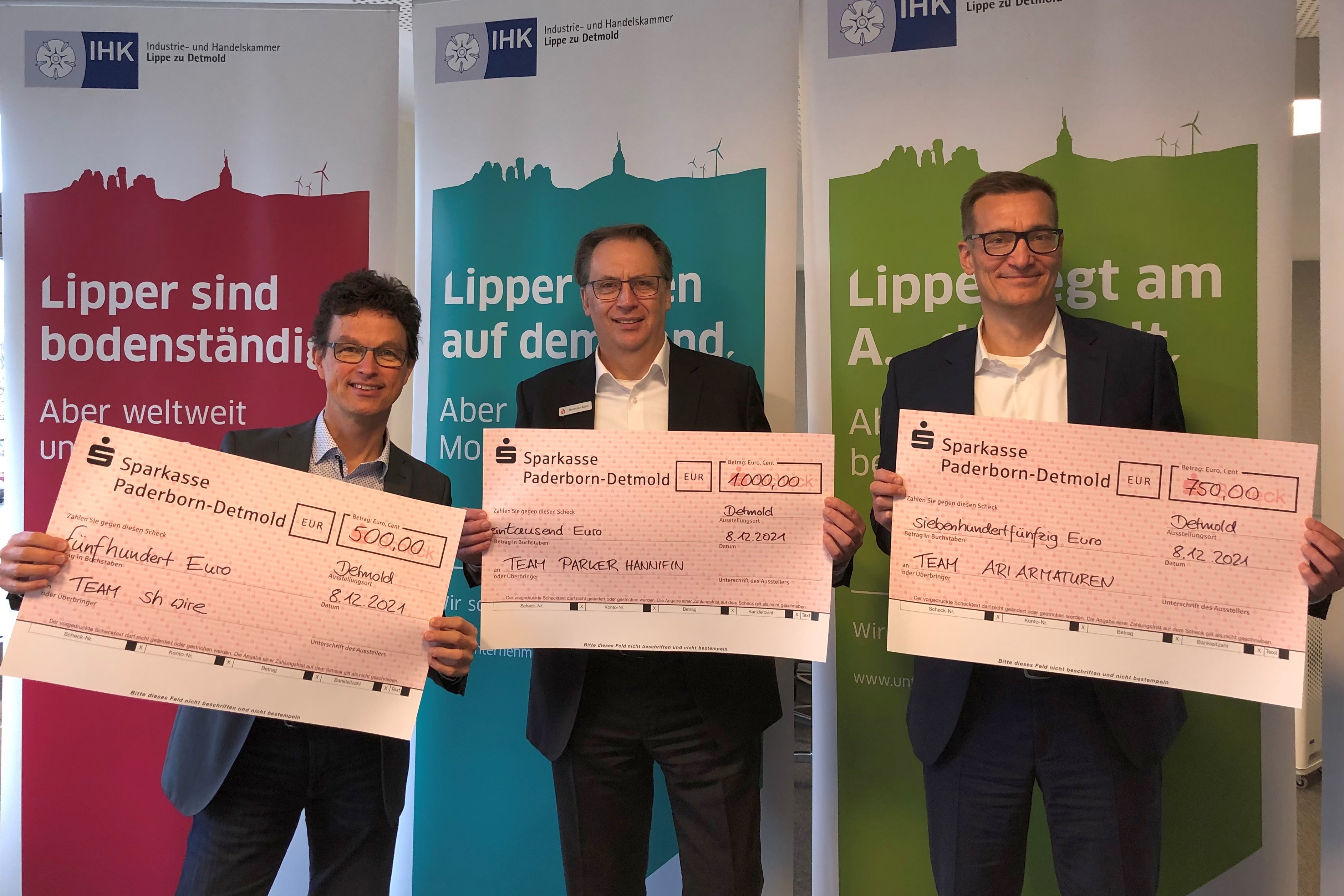 Matthias Carl (IHK Lippe zu Detmold), Thorsten Kost (Sparkasse Paderborn-Detmold) und Arne Potthoff (IHK IHK Ostwestfalen zu Bielefeld) überreichten „symbolisch“ die Siegerschecks (v. l. n. r.). Foto: IHK Lippe